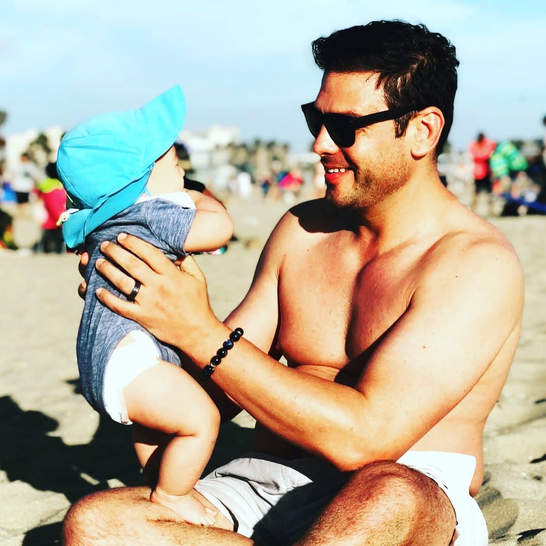 Roland holding baby Koji on the sand
