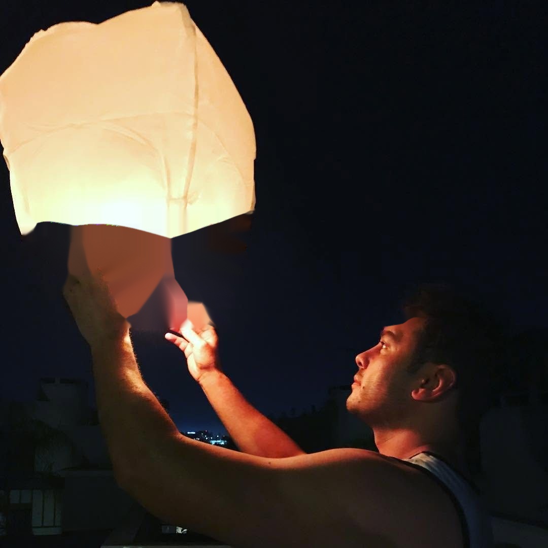 Roland releasing a sky lantern at night